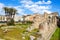 Ancient Greek ruins of the Temple of Apollo in Ortigia Island, Syracuse, Sicily, Italy photographed with adjacent palm trees.