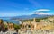 Ancient Greek theatre in Taormina on background of Etna Volcano, Italy