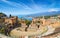 Ancient Greek theatre in Taormina on background of Etna Volcano, Italy