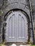 Ancient grey castle arched door with studded pattern