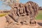 Ancient Hindu god sitting on myth lion creature, ruins of stone relief carvings from the 7th century temple, Karnataka.