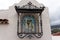 Ancient icon hangs on the outer wall of the house behind a beautiful wrought-iron fence on the island of Tenerife in Spain