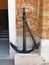 Ancient iron black anchor over red brick wall background