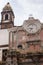 Ancient italian church with small cross and old clock. Time and religion concept. Vintage exterior building. Abandoned church.