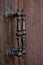 Ancient Italian metal door handles on brown wooden door