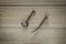 Ancient key and old bent nail on wooden background