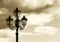 Ancient lamppost against a cloudy sky, vintage