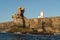 Ancient lighthouse and sunlit cliffs of Carvoeiro cape in Peniche, Atlantic coast, Portugal