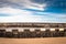 Ancient medieval fortress barrier wall on sandy beach as breakwater, in sunny blue sky with clouds, creative background design