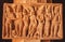 Ancient men and women figures on stone relief of 7th century Hindu templ. Carved architecture of India.