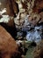 Ancient mountain cave with stalactites, stalagmites, long underground river in white and red stones with petroglyph