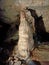 Ancient mountain cave with stalactites, stalagmites, long underground river in white and red stones with petroglyph