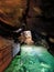 Ancient mountain cave with stalactites, stalagmites, long underground river in white and red stones with petroglyph