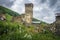 Ancient old Svan tower in mountain village on green grassy hill, Svaneti region in Georgia.