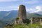 Ancient Ossetian battle tower against the background of the Caucasian mountains