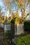 Ancient overgrown tombstones and graves at churchyard garden on autumn morning.