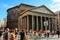 Ancient pantheon exterior daytime with crowded square in Rome, Italy