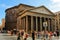 Ancient pantheon exterior daytime with crowded square in Rome, Italy