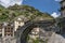 The ancient Pont Saint Martin bridge, in the historic center of the homonymous village, on a sunny day, Aosta Valley, Italy