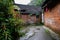 Ancient red-brick dwelling houses in alley after rain