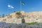 Ancient remnants of Ceasarea and waving flag of Israel in Maritima National Park in Caesarea, Israel