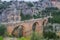 Ancient roman aqueduct with a man walking on it