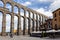 Ancient roman Aqueduct of Segovia, Spain, monumental water distribution system with city street.