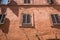 Ancient Roman buildings wall with wooden windows under the sunlight