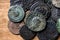 Ancient Roman coins with emperors portraits close-up, pile of old metal money on vintage background, top view. Concept of Rome,