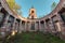 Ancient rotunda with columns without a dome on the bell tower of the background and blue sky at sunset