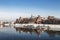 Ancient Royal Wawel castle on the banks of the Vistula river with tourist boats at the pier in winter, Krakow