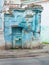 Ancient ruined blue building. Destroyed cyan house. Travel street photo. Turquoise weathered wall