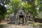 Ancient ruins of Banteay Kdei temple in Angkor Wat complex, Cambodia. Demolished stone tower with Buddha face.