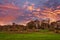 Ancient Ruins of Dundonald Castle and the village church Spier of Dundonald Scotland at sunset with a blazing red Sky