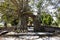 Ancient ruins gate entrance with bodhi tree and banyan plant of Wat Phra Ngam Khlong Sa Bua temple for thai people travel visit