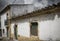 Ancient rustic house next to a modern building on a cloudy day