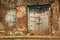 An ancient rustic wooden door on an old, laterite brick wall in the heritage town of