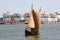 Ancient sailing boat in the port oil terminal in the background