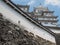 Ancient samurai castle in Himeji city in Japan with white walls, dark tile roofs and stone walls on a sunny day in summer with blu