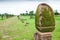 Ancient sculpture sandstone pillars at Vat Phou, South Laos. Fresh grassland and tropical trees backgrounds. Public park. UNESCO