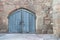 Ancient single wooden castle door in old city wall. Arched medieval wooden door in a stone wall.