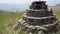 An ancient small pyramid shaped worship idol dedicated to Lord Shiva prayer place made of stones in the middle of a meadow with