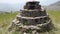 An ancient small pyramid shaped worship idol dedicated to Lord Shiva prayer place made of stones in the middle of a meadow with