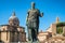 Ancient statue of Julius Caesar in Rome with Santi Luca e Martina church at background