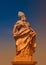 Ancient statue of Saint Fridericus at old city bridge illuminated with golden sun at sunset in Wurzburg, Germany, summer, details