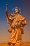 Ancient statue of Saint Nepomuk at old city bridge illuminated with golden sun at sunset in Wurzburg, Germany, summer, details