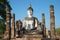 Ancient statue of a sitting Buddha. Ruins of the Buddhist temple Wat Mahathat in the Park of Sukhothai. Thailand