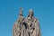 Ancient statue of two monks with Bible at the Charles Bridge in Prague at blue sky, Czech Republic, summer, closeup