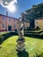 Ancient statue of a woman on a green flowerbed in front of Villa Cordevigo. Italy
