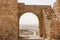 Ancient stone arch and wall with desert view durin